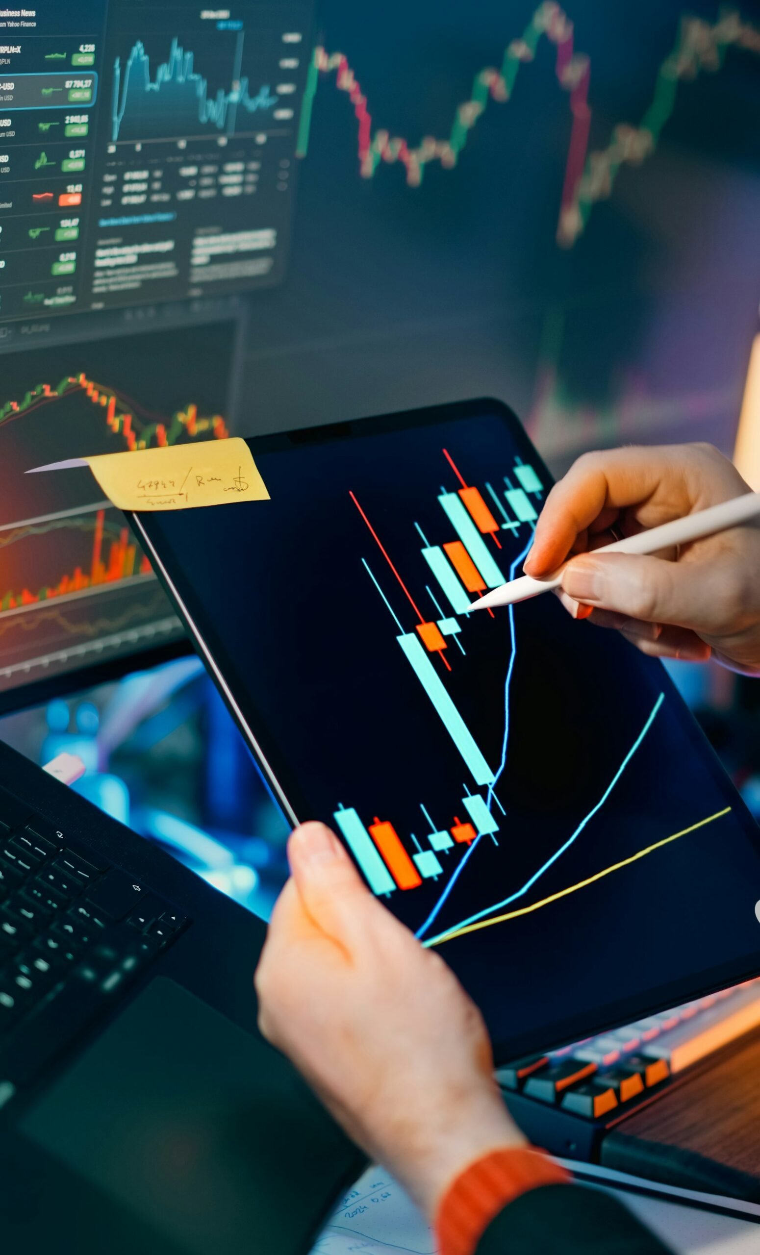 Trader analyzing market charts on tablet and monitor